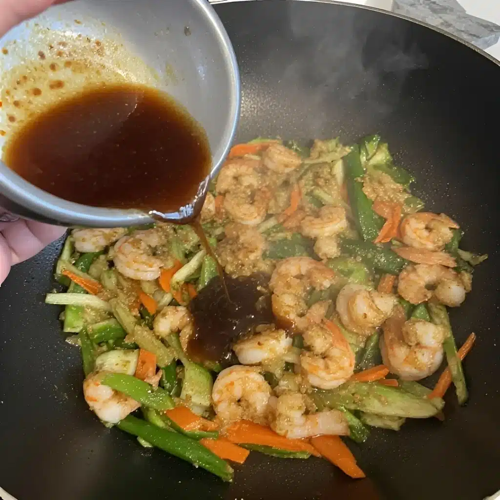Shrimp Stir Fry with Tamari Sauce (Easy & Flavorful) 6 Pouring tamari sauce into shrimp stir fry in wok