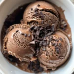 Ultimate Dairy-Free Dessert Recipes (No-Bake, Creamy, & Kid-Friendly) 5 Creamy scoops of chocolate dairy-free ice cream in a bowl.