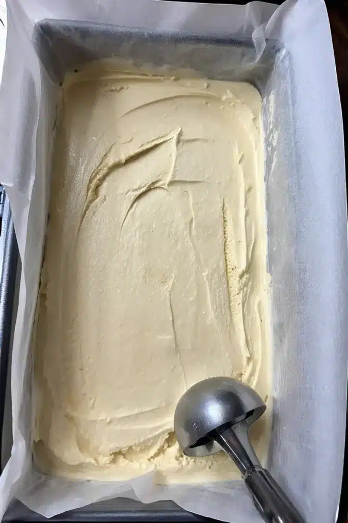 Creamy Vanilla Dairy-Free Ice Cream – Budget-Friendly Healthy Dessert 4 Vanilla dairy-free ice cream stored in loaf pan with parchment pape